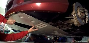 Lifting the Front Under Tray into place on an Aston Martin DB9